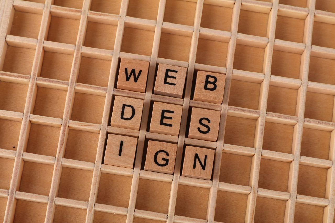 Wooden blocks spelling web design on a grid background symbolizing creative digital design concepts.